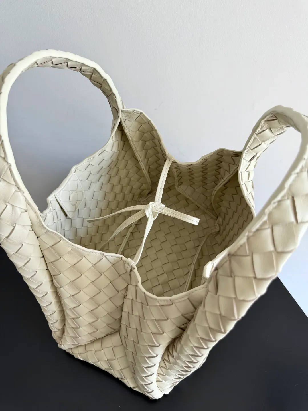 Batch 2160 new products are coming! BOTTEGA VENETA Bottega Veneta's 2025 new Campana shoulder bag is on the market~ First of all, I would like to praise the weight of this bag. As a not too small bag, it is very light for daily use. For people like me who need to carry a lot of belongings when going out, this advantage is great, and it greatly reduces the burden of traveling. 🛍️The shape is a bit like a combination of parachute and jodie. The blunt triangle shape is cute and honest. Carrying it on your back when going shopping is a good mood accelerator. The handles and body of the bag are both classic weaves. A tie is added to the original open design. If it is not tied up, the bag will look like a small vegetable basket when carried. Style number: 844249 Size: 33*20*16.5cm
